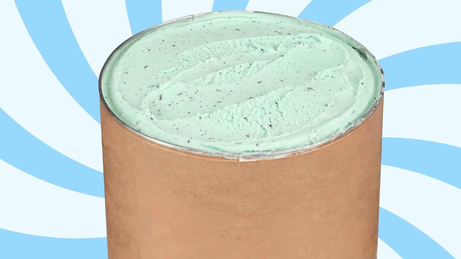 Mint chocolate chip ice cream in a brown cardboard tub, opened to reveal pale green ice cream with small chocolate flecks.